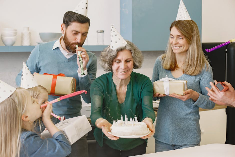 A happy family celebrating with gifts, cake, and party hats indoors, showcasing togetherness and joy.