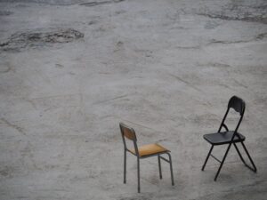 Minimalist photograph featuring two chairs on a concrete surface in Hong Kong.