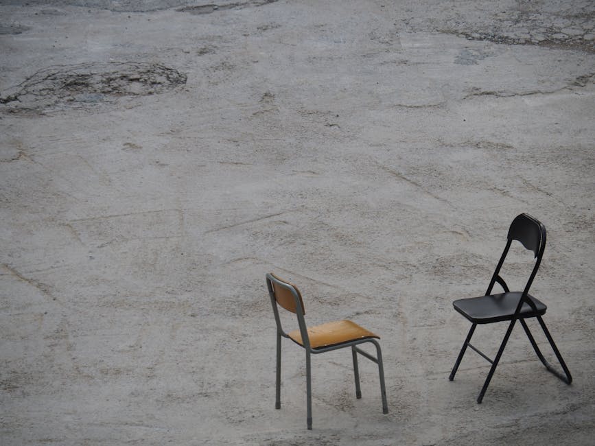 Minimalist photograph featuring two chairs on a concrete surface in Hong Kong.