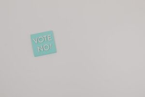 Simple image of a 'Vote No!' message on a gray surface with ample copy space.