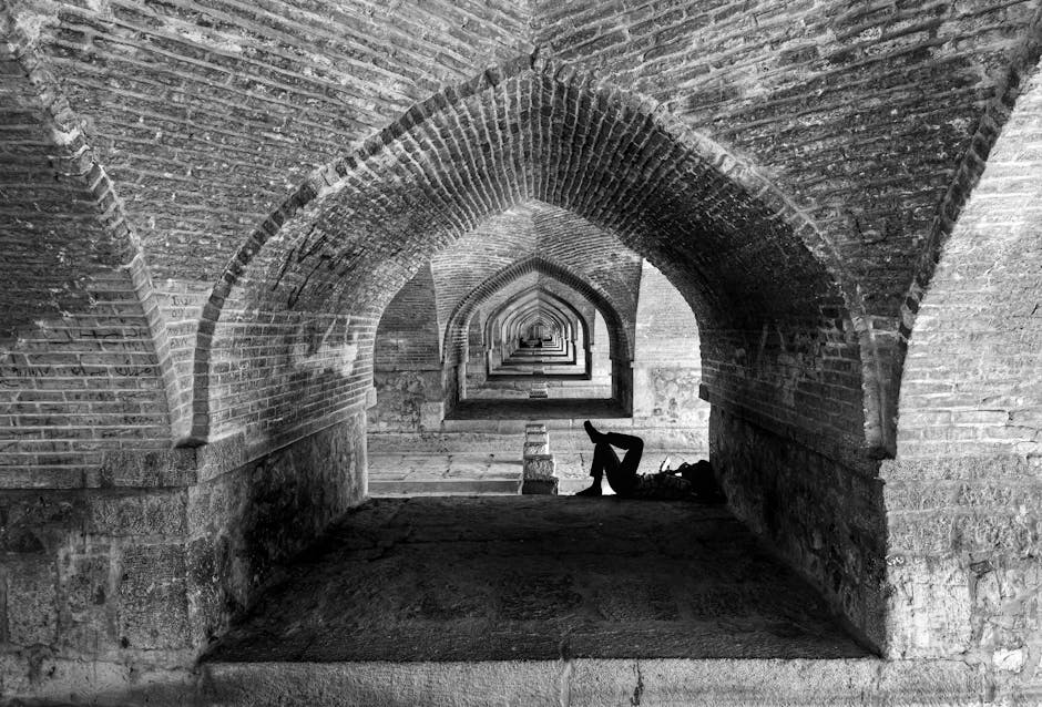Relaxing under historic arches of the Si-o-se-pol Bridge, capturing architectural beauty in Esfahan.