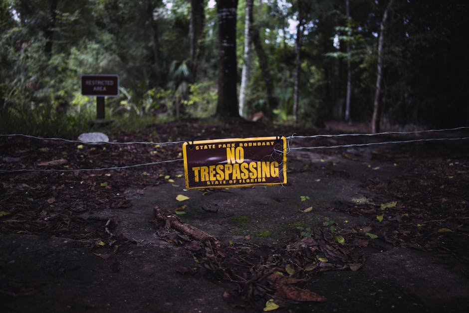 Vintage no trespassing sign on a forest path at state park boundary in Florida.