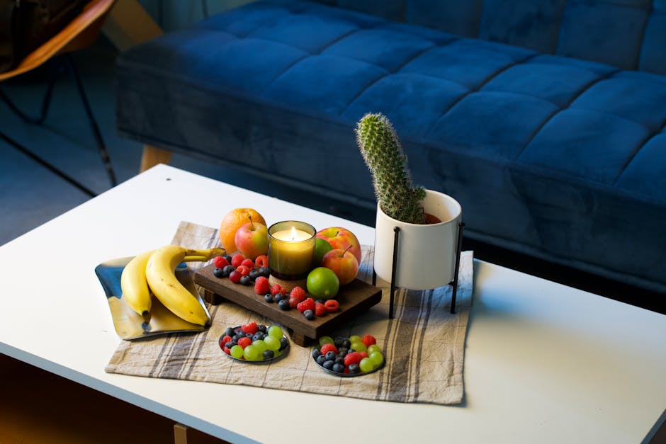 A cozy indoor setup featuring a cactus plant and assorted fruits on a wooden tray.