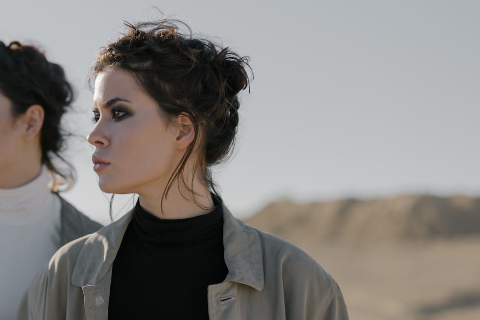 Profile portrait of a woman with makeup in an outdoor desert landscape. Moody fashion shot.