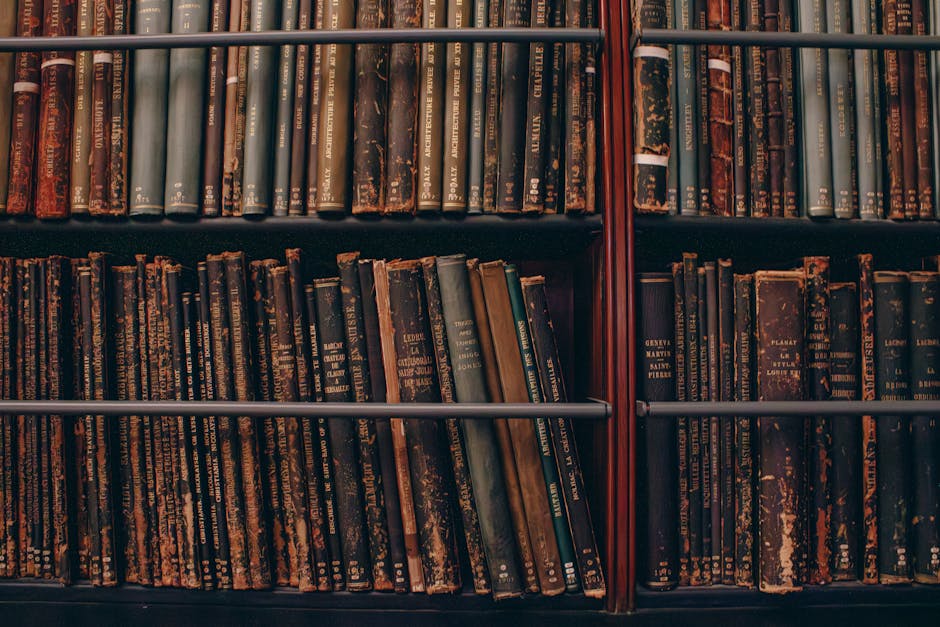 A collection of aged, classic books lined up on wooden shelves, evoking a vintage aesthetic.