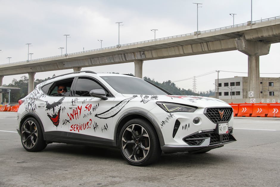 White SUV decorated with Joker-inspired art on a highway under bridge.