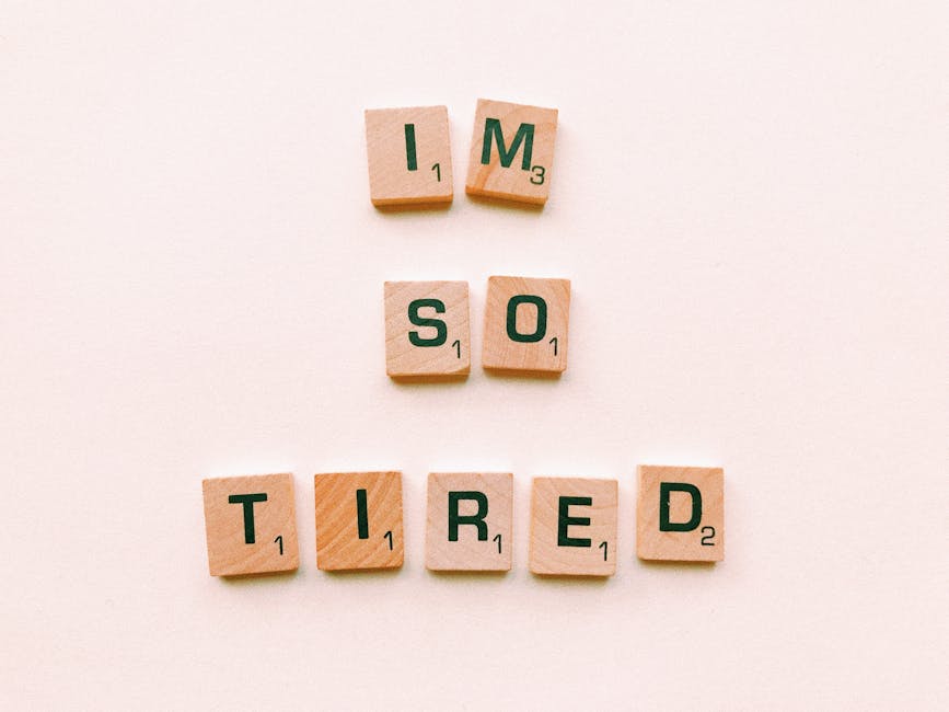 Close-up of Scrabble tiles spelling 'I'm So Tired' on a plain surface, capturing a conceptual theme.