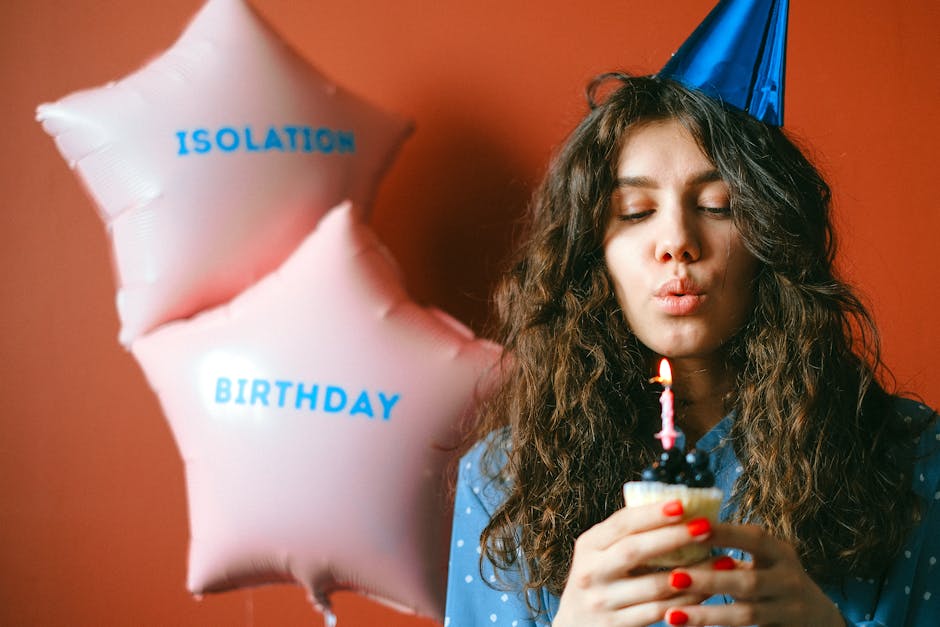 A woman celebrates her birthday with balloons and a candle-lit cupcake, creating a joyful and vibrant atmosphere.