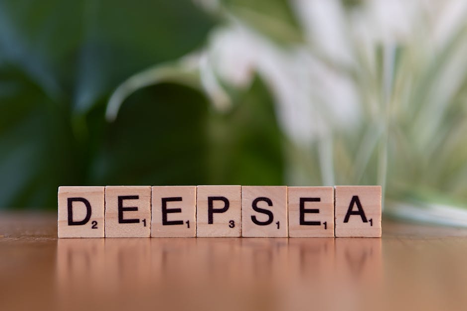 Wooden blocks spelling 'Deep Sea' set against a blurred green background for a natural theme.